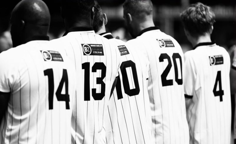 Footballers wearing shirts with Broker Zone sponsorship on the back at Tom Pope’s retirement match
